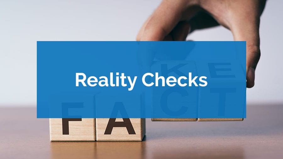 Wooden blocks spelling 'FAIL' with a blurred background and 'Reality Checks' text.